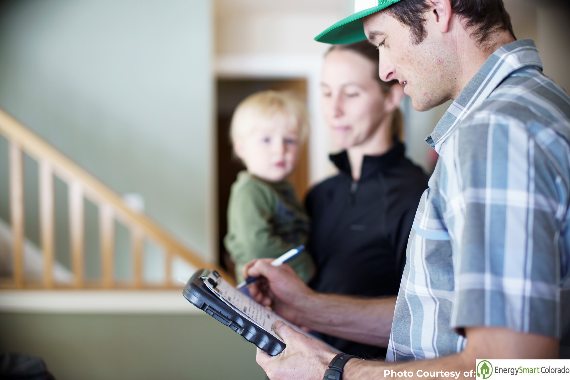An energy auditor speaks to a family about energy assessments